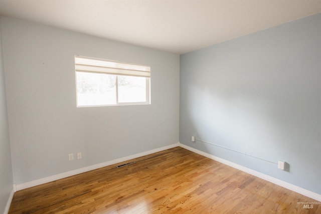 empty room with light wood-style flooring and baseboards