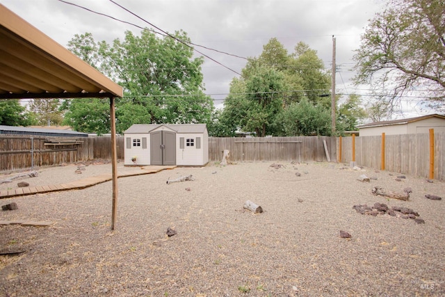 fenced backyard with a shed and an outbuilding