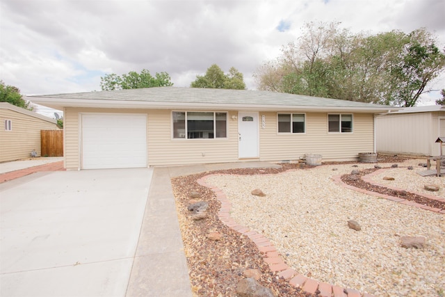 single story home featuring concrete driveway, fence, and a garage
