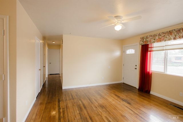 foyer entrance with hardwood / wood-style floors, a ceiling fan, and baseboards
