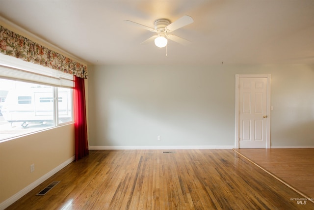 empty room featuring ceiling fan, wood finished floors, and baseboards