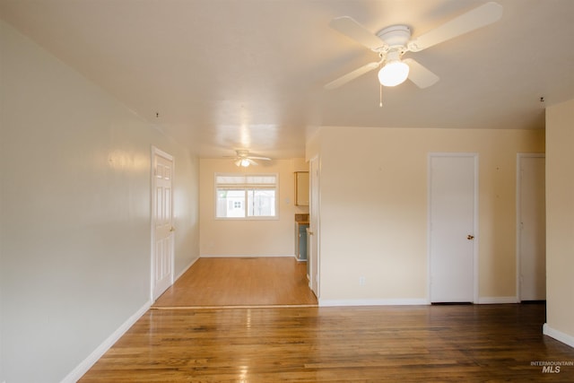 spare room featuring a ceiling fan, wood finished floors, and baseboards