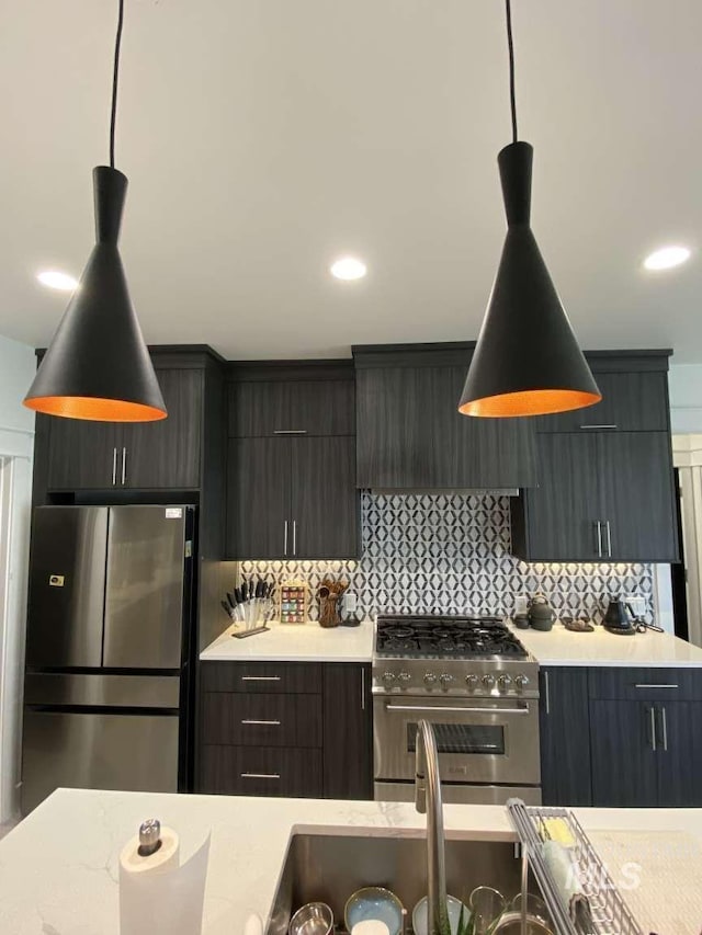 kitchen featuring backsplash, decorative light fixtures, wall chimney exhaust hood, and stainless steel appliances