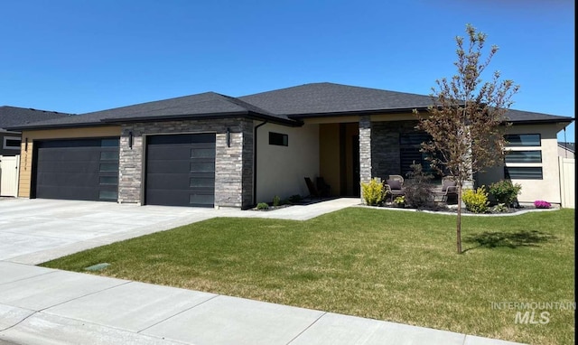 prairie-style house featuring a garage and a front lawn