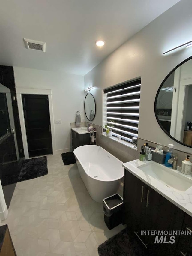 bathroom with vanity and a tub to relax in