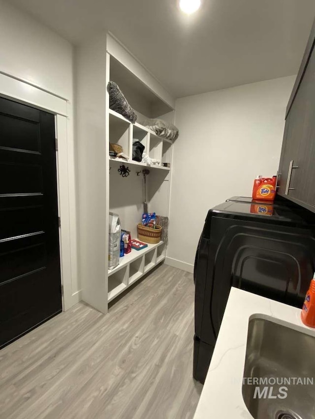 laundry room featuring light hardwood / wood-style floors, independent washer and dryer, and sink