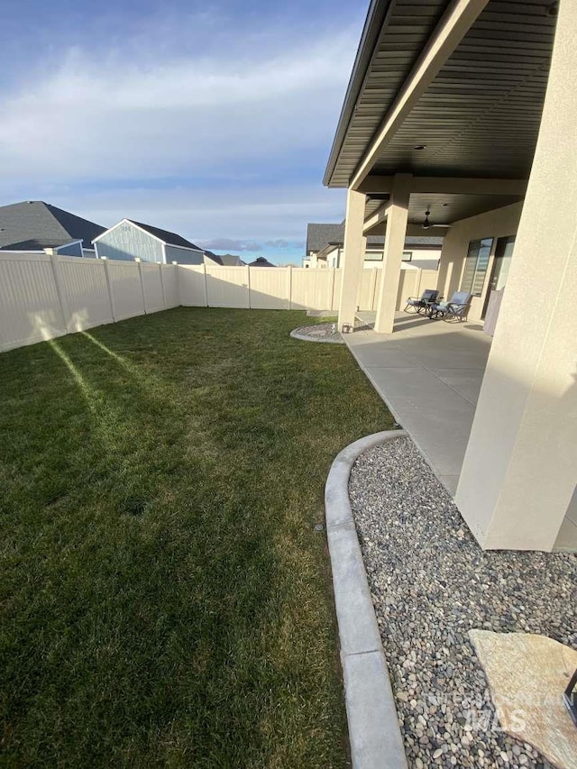 view of yard featuring ceiling fan and a patio