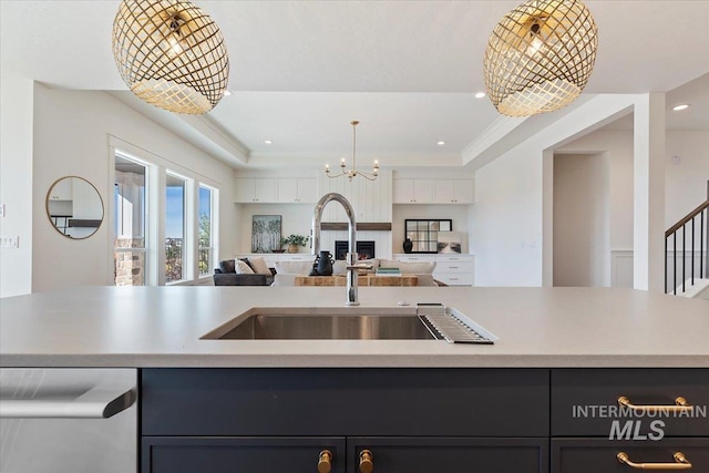 kitchen featuring dishwasher, a chandelier, a tray ceiling, and hanging light fixtures