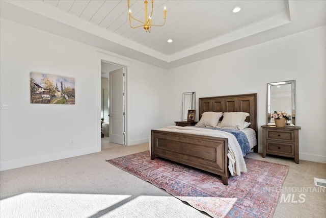 bedroom featuring an inviting chandelier, light carpet, and a tray ceiling