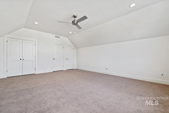 additional living space with light carpet, ceiling fan, and vaulted ceiling