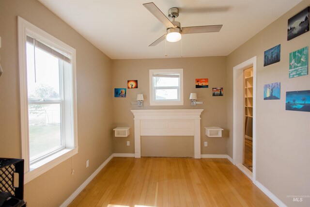 260 State St, Grand View, ID 83624 - living area with light wood-style flooring, a fireplace, ceiling fan, and baseboards