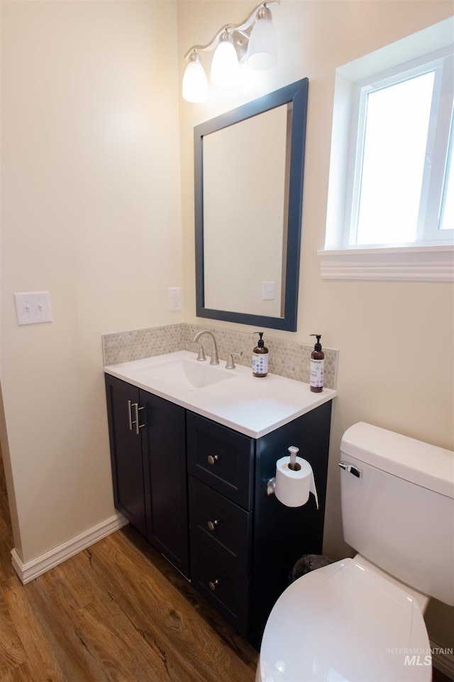 260 State St, Grand View, ID 83624 - half bathroom with wood finished floors, vanity, toilet, and baseboards