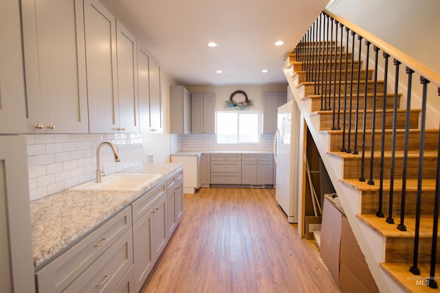 260 State St, Grand View, ID 83624 - kitchen with a sink, gray cabinets, light wood-style floors, tasteful backsplash, and freestanding refrigerator