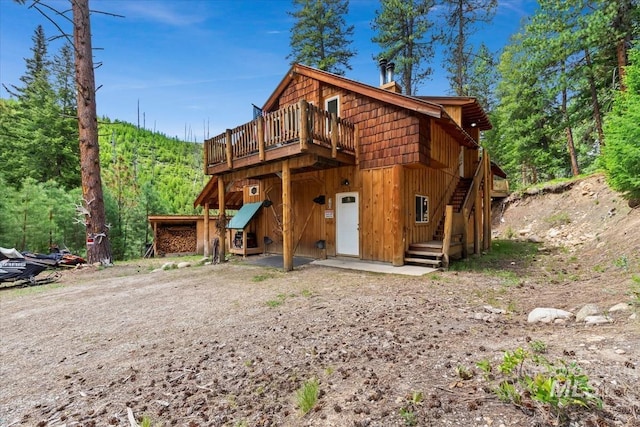 150 W Yuba Vista Dr, Atlanta, ID 83716 - view of front of property featuring a wooden deck, stairs, and a view of trees