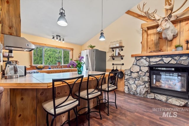 150 W Yuba Vista Dr, Atlanta, ID 83716 - kitchen with freestanding refrigerator, tile counters, dark wood-style flooring, lofted ceiling, and a kitchen breakfast bar