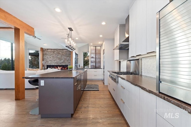 kitchen with a large island, a breakfast bar, appliances with stainless steel finishes, white cabinets, and pendant lighting