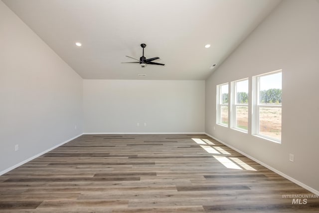 empty room with ceiling fan, high vaulted ceiling, and light wood-type flooring