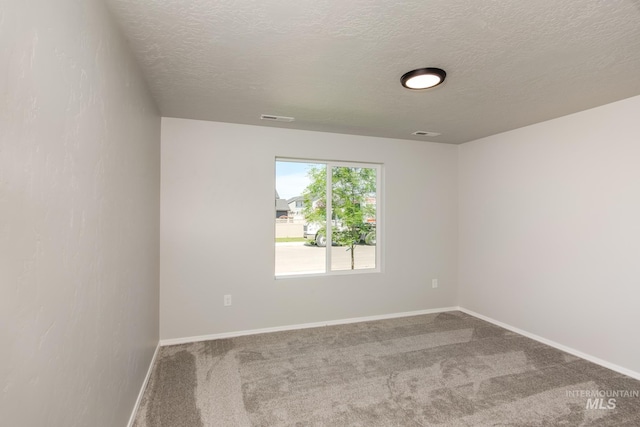 unfurnished room featuring a textured ceiling and carpet flooring