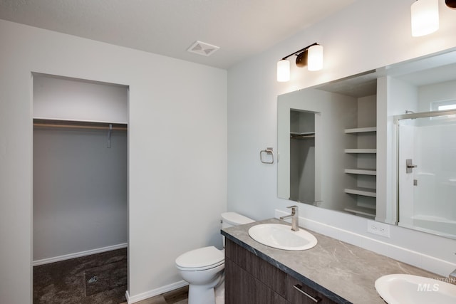 full bathroom featuring a walk in closet, visible vents, a sink, and double vanity