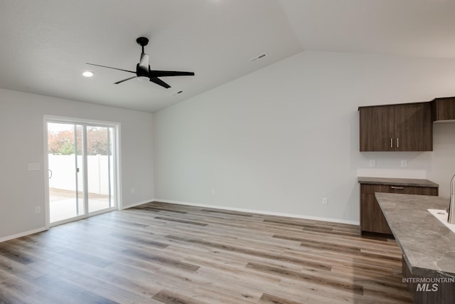 unfurnished living room with visible vents, baseboards, lofted ceiling, ceiling fan, and light wood-type flooring