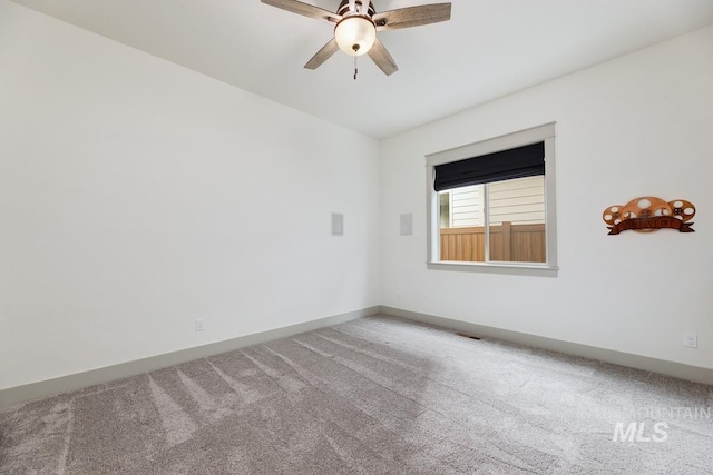 carpeted empty room featuring ceiling fan and baseboards