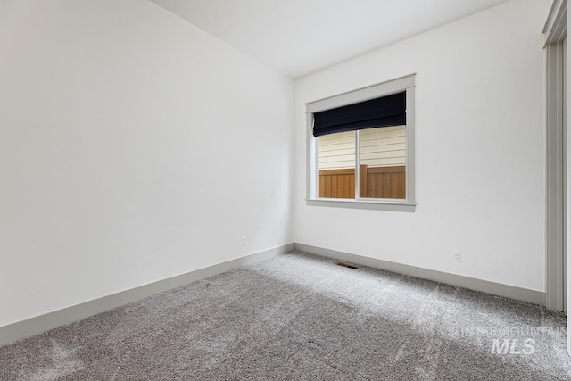 carpeted empty room with visible vents and baseboards
