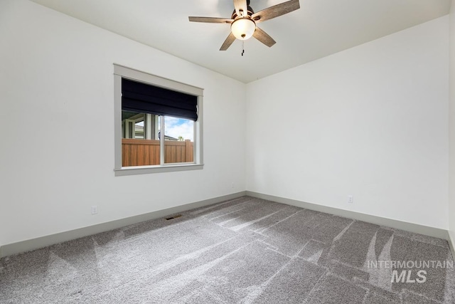 carpeted spare room with baseboards and ceiling fan