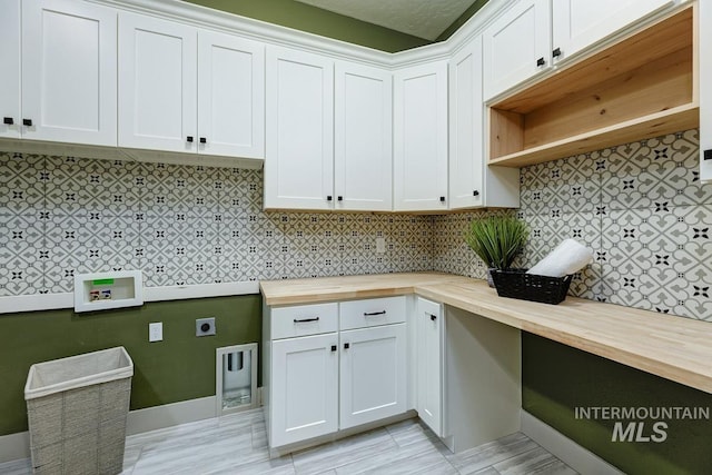 laundry room with electric dryer hookup and cabinet space