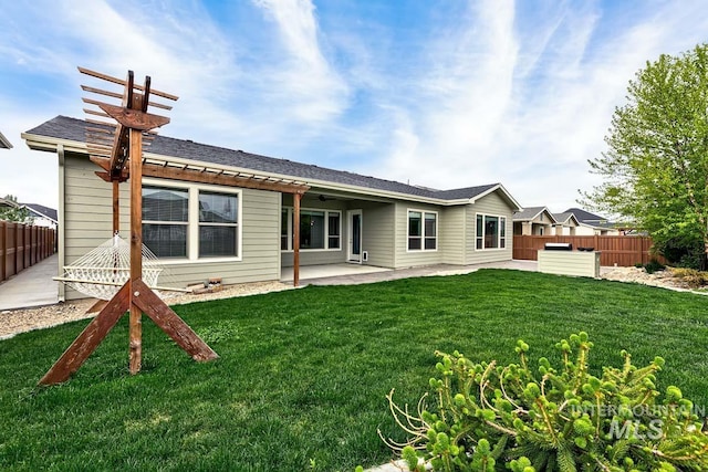 back of property with fence, a patio, and a yard