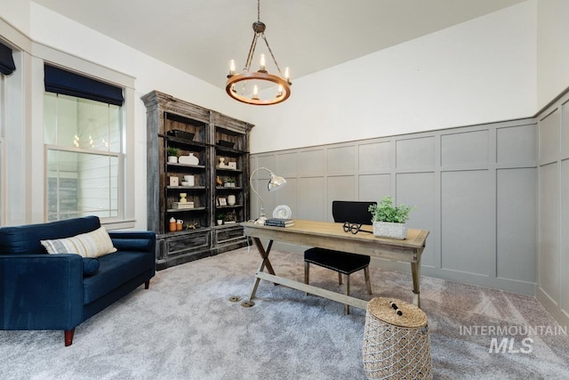 carpeted office with a decorative wall, a chandelier, and a wainscoted wall