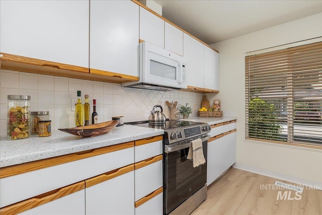 498 E Chester Ln, Boise, ID 83706 - kitchen featuring white microwave, stainless steel electric range oven, light wood finished floors, light countertops, and tasteful backsplash