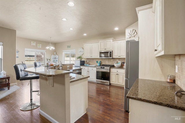 1020 Woodland St, Rupert, ID 83350 - kitchen featuring stainless steel appliances, recessed lighting, backsplash, a chandelier, and dark wood-type flooring