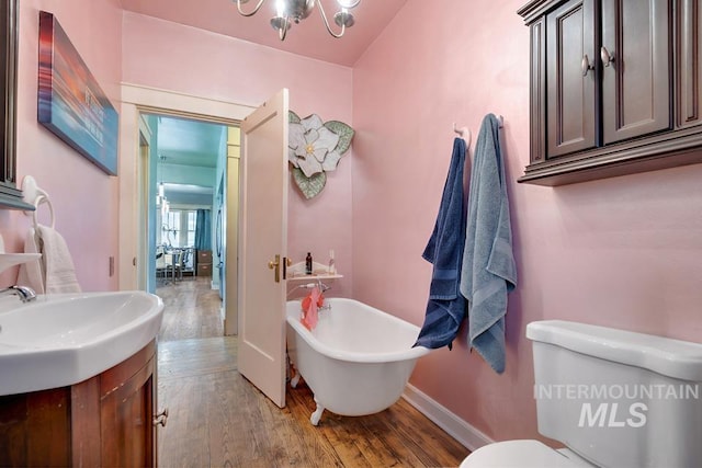 937 SW 1st St, Ontario, OR 97914 - full bath with wood finished floors, a soaking tub, vanity, and a chandelier