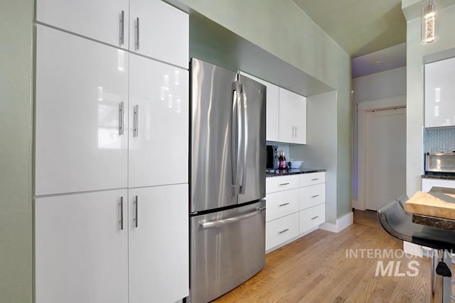 937 SW 1st St, Ontario, OR 97914 - kitchen featuring freestanding refrigerator, light wood-style floors, white cabinetry, decorative backsplash, and modern cabinets