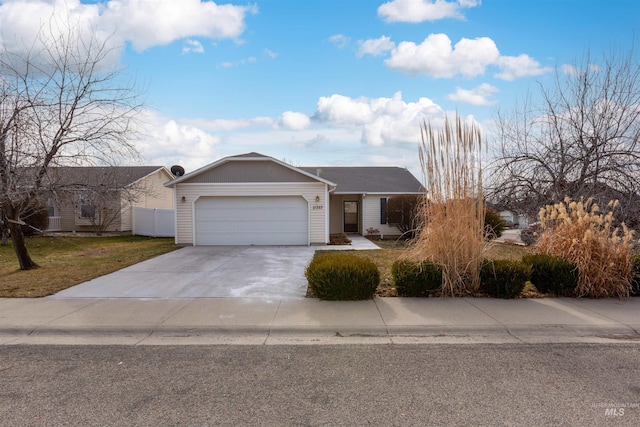 single story home featuring a front lawn, an attached garage, fence, and driveway