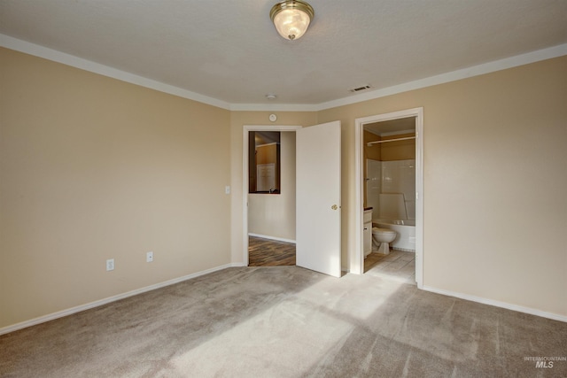 unfurnished bedroom with visible vents, ensuite bathroom, baseboards, and carpet floors