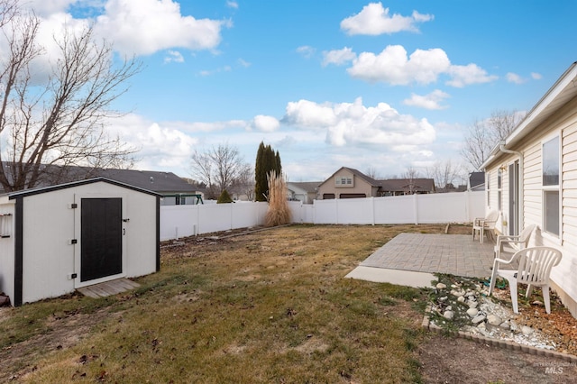 view of yard with an outdoor structure, a patio area, a fenced backyard, and a shed