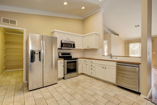 kitchen featuring visible vents, appliances with stainless steel finishes, crown molding, and a sink