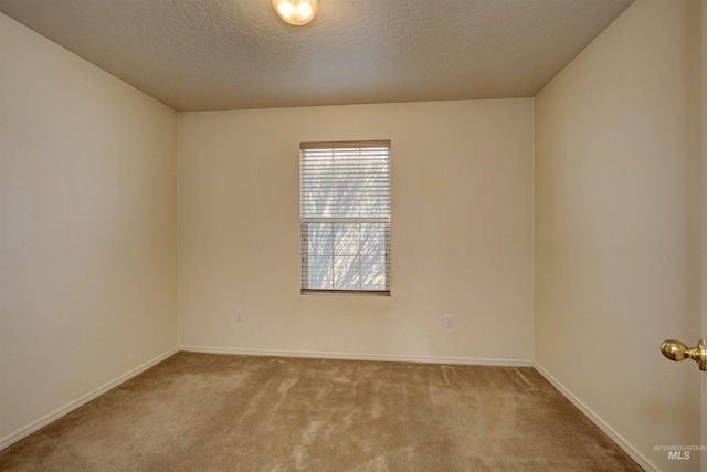 carpeted spare room with baseboards and a textured ceiling