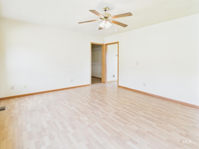 unfurnished room featuring baseboards, ceiling fan, light wood-style flooring, and visible vents