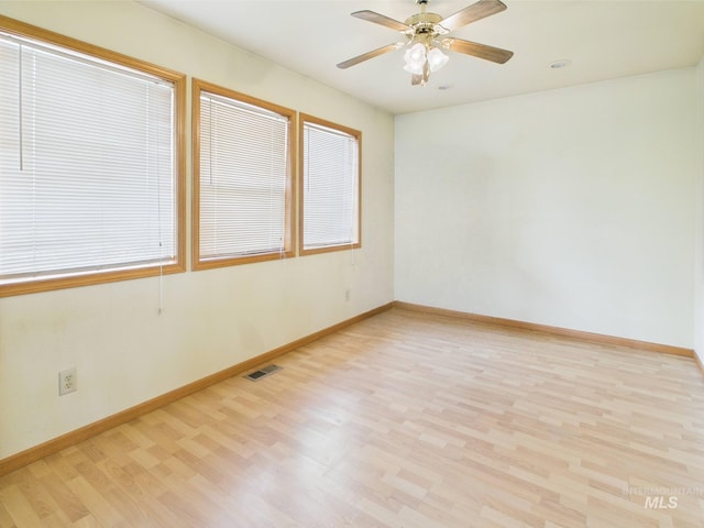 spare room with visible vents, light wood-style floors, ceiling fan, and baseboards
