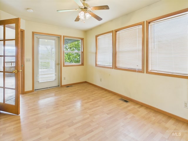 interior space with a ceiling fan, baseboards, visible vents, and light wood-type flooring