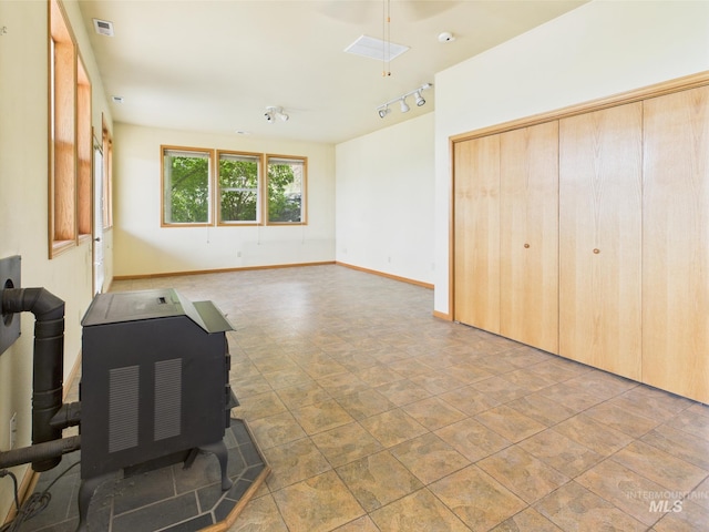 unfurnished living room with track lighting, baseboards, and visible vents