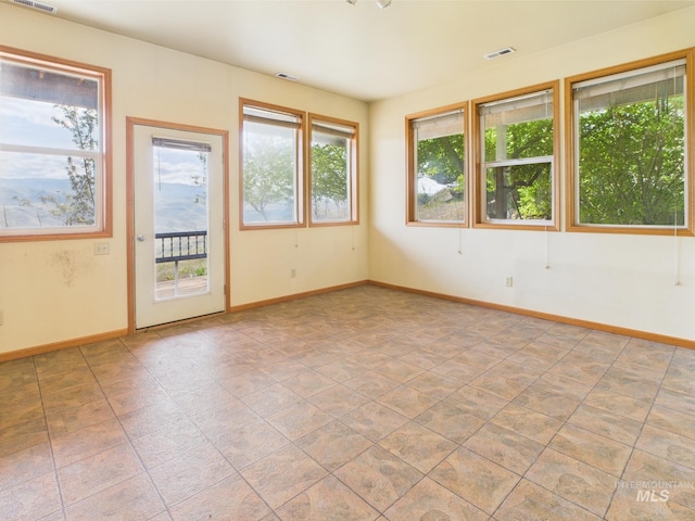 spare room featuring baseboards and visible vents