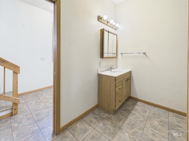 bathroom with baseboards, tile patterned floors, and vanity