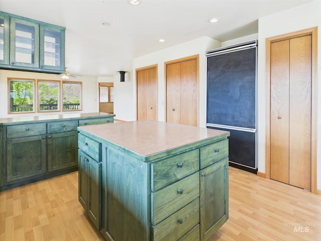 kitchen with a kitchen island, light wood-style floors, ceiling fan, and green cabinets