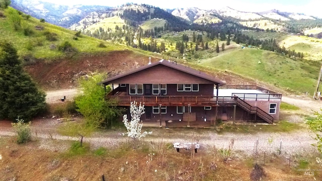 rear view of house featuring stairway and a deck with mountain view