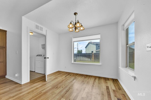 1295 NE Blossom, Mountain Home, ID 83647 - unfurnished dining area with light wood-style floors, a chandelier, independent washer and dryer, and baseboards
