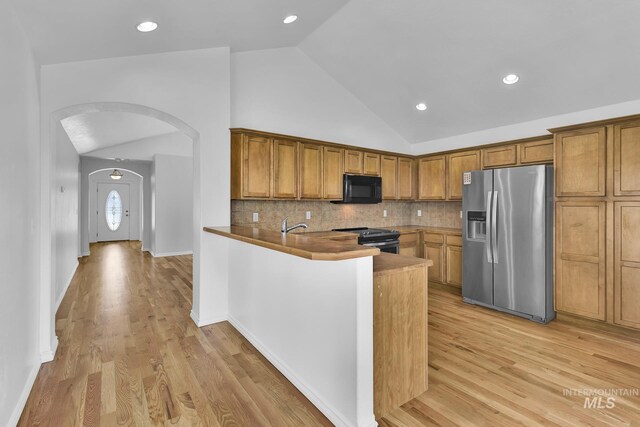 1295 NE Blossom, Mountain Home, ID 83647 - kitchen featuring appliances with stainless steel finishes, arched walkways, brown cabinetry, light wood-type flooring, and recessed lighting