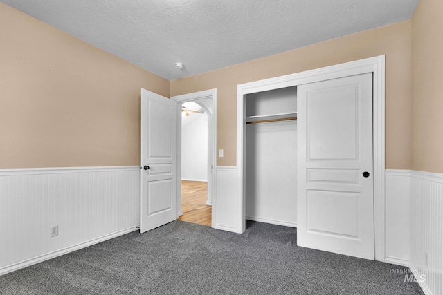 1295 NE Blossom, Mountain Home, ID 83647 - unfurnished bedroom featuring wainscoting, carpet flooring, a textured ceiling, and a closet